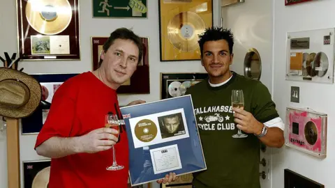 Getty Images Pop star Peter Andre is presented with a silver disc by Korda Marshall in March 2004, in recognition of 200,000 copies of his re-released single Mysterious Girl being sold.