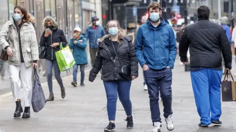 PA Media People wear masks in Manchester city centre