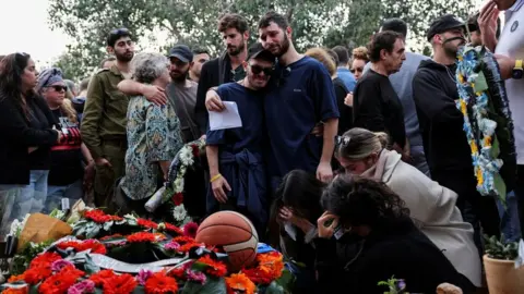 Reuters Friends of family of Alon Lulu Shamriz mourn him at his funeral in Shefayim, Israel, after he was mistakenly killed by Israeli forces in Gaza (17 December 2023)