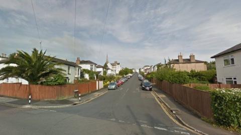 A Google Steet View of Wood Street, Ryde, taken from one end looking down. There are several cars parked on either side of the road and there are double yellow lines on both corners