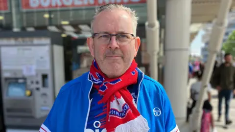 Crystal Palace supporter Brendan in a blue jacket and club scarf.