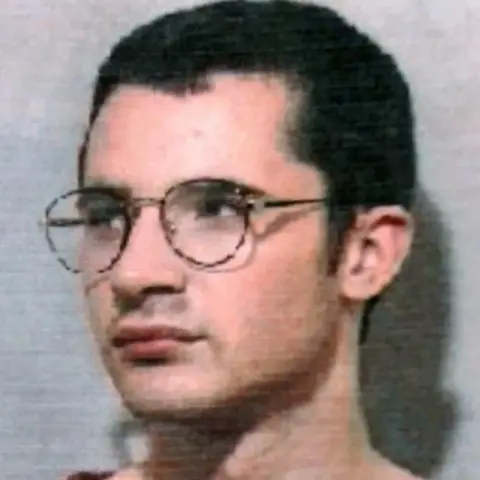 PA A mugshot of McKilligan who has short, dark hair and large round glasses.