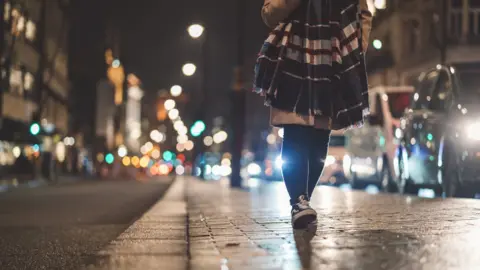 Getty Images Young woman at Piccadilly Circus at night