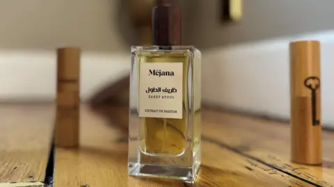 Sebastian Usher A bottle of Mejana perfume on a wooden table