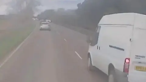 White van on the wrong side of the road after a dangerous overtaking manoeuvre on the A10 in Cambridgeshire.
