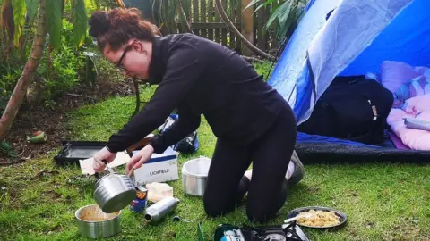 Rebecca Barnett Izzy Fellows-Barnett with camp cooking equipment