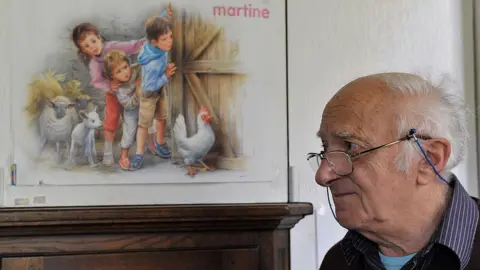 Getty Images Belgian artist and illustrator Marcel Marlier posing near his drawings of the children's series 'Martine' at his home near Tournay - 2010