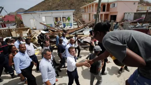 AFP French President Emmanuel Macron shakes hands with residents during a visit to Saint-Martin on 12 September