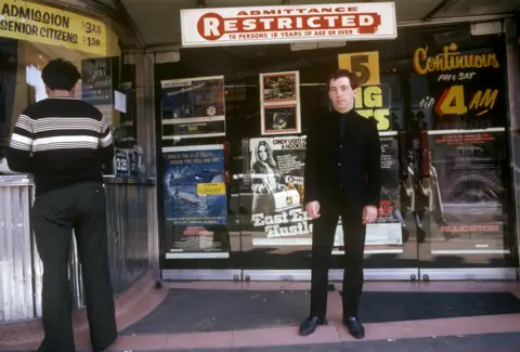 Getty Images Pete Shelley poses outside a cinema in Canada
