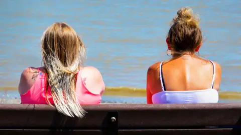 Getty Images Two women on bench by the sea