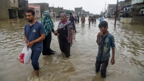 Getty Images People in flooded water