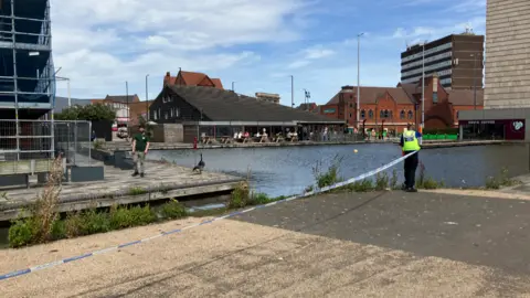 BBC A canal cordoned off by a police officer 