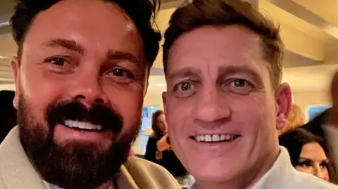 Ray Quinn Ray Quinn, who has dark hair swept back and a dark beard and wears a beige woollen jacket, poses with Philip Olivier, who has dark blonde hair