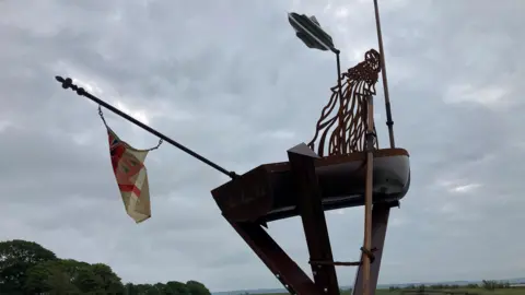 BBC Metal sculpture represents a Wren waving a white handerchief