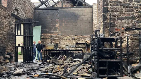 The charred remains of the inside of a stone barn  