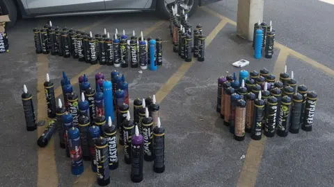 Surrey Police Black and blue NOS cannisters on the floor.
