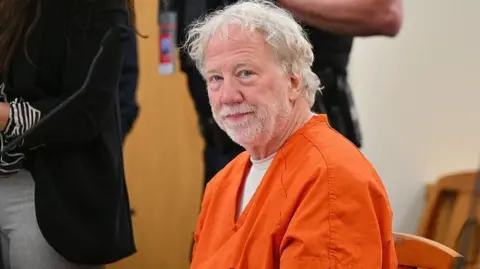 Actor Timothy Busfield wears an orange jail attire and looks on as he is seated in a New Mexico courtroom during a pretrial hearing on 20 January 2026.