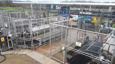 Anglian Water Equipment at a sewage treatment works in Whitlingham can be seen, with workers in the background