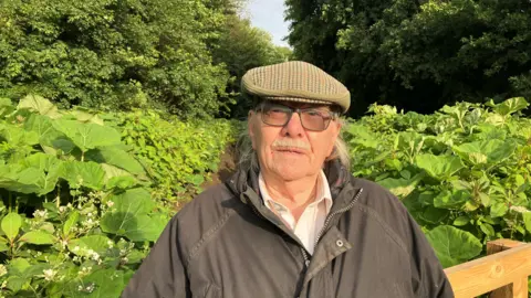 Photograph of 90 year-old Roy Anderton from Hindley. He is standing in the Low Hall Nature Reserve in Platt Bridge, Wigan.