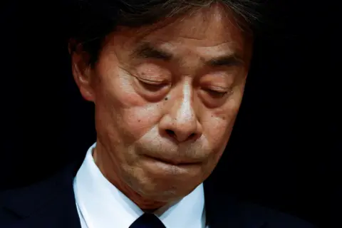 Fuji TV president Koichi Minato looking down as he apologises