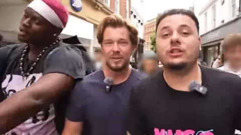 TikTOk/J2Hundred J2Hundred and two other streamers can be seen in a screenshot from a TikTok video while being followed by large crowds through Norwich