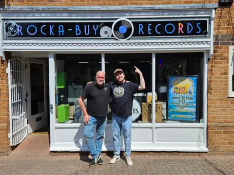 Rockabuy Records An image of two men standing in front of a record shop