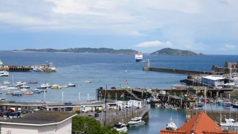 View of St Peter Port harbour in Guernsey with a ferry arriving.