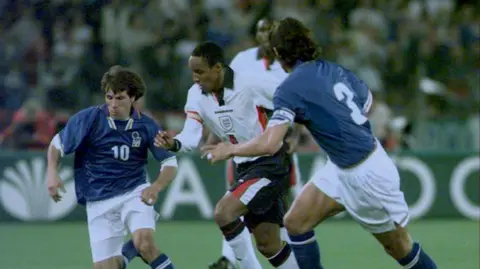 PA Media Paul Ince, wearing a white England shirt and darks, bursts past Italian player Gianfranco Zola during a World Cup qualifying game in Rome