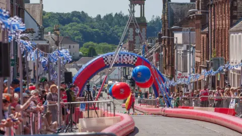Keith Kirk Photographer A winding track looking down the street towards a large red and blue blow-up finsih line.