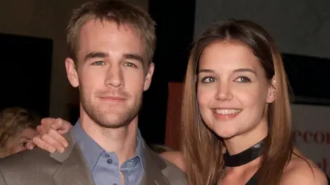 Katie Holmes with her arm around James Van Der Beek in 2002