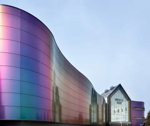 Merry Hill The exterior of Merry Hill shopping centre is a curved iridescent wall leading to a glass-fronted atrium with the name of the shopping centre 