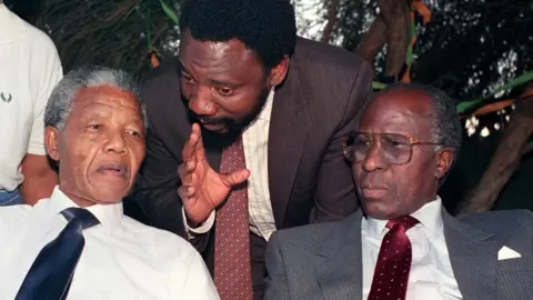 Getty Images Nelson Mandela (L) and Andrew Mlangeni (R) listen to Cyril Ramaphosa