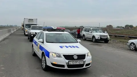 AZERBAIJAN GOVERNMENT A handout picture made available by the Ministry of Emergency Situations of Azerbaijan shows vehicles deployed by the Ministry of Emergency Situations of Azerbaijan, on their way to deliver humanitarian aid to Armenian civilians in the Karabakh region