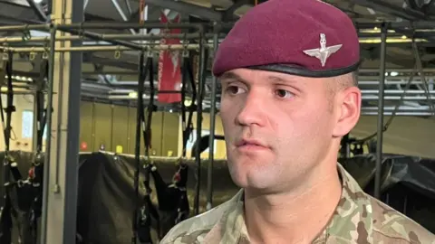 Jamie Niblock/BBC Private Shayne Wilkinson, 3rd Battalion The Parachute Regiment - paratrooper involved in security and crowd management at evacuation handling centre.