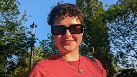 Lola Hibberd Lola Hibberd in a red top and sunglasses