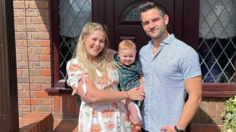 Ashlee Colvin Ashlee holding her baby with her husband