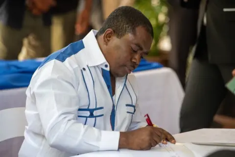 EPA Haitian opposition leader Andre Michel signs a political agreement between the main opposition parties and the Government of Prime Minister Ariel Henry, in a ceremony at his official residence in Port-au-Prince, Haiti, 11 September 2021.