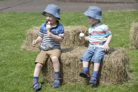 PA Brothers Oliver (left) and Benjamin Scott enjoy an ice cream at The Green in Heckmondwike, Yorkshire - Sat 17th June