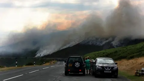 Getty Images Motorists watch the wildfire above Horseshoe Pass in North Wales