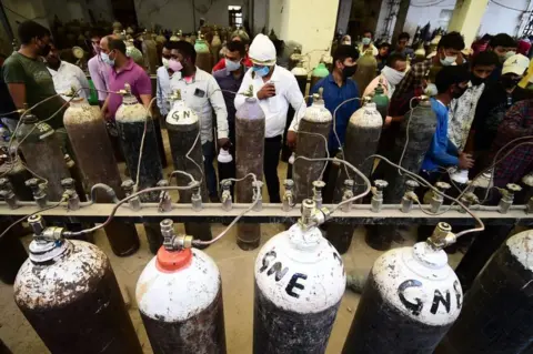 Getty Images Relatives of Covid patients have been queuing up in cities to refill cylinders