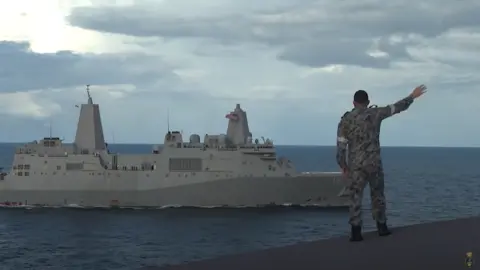 ROYAL AUSTRALIAN NAVY An Australian soldier waves to a US navy ship during a joint exercise in the Pacific