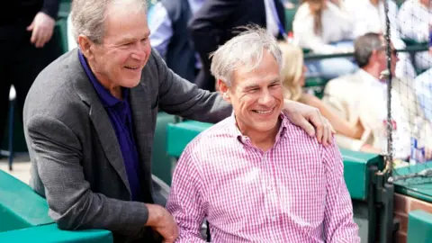 Getty Images Governor Abbott at a baseball game with former president George W Bush