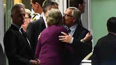 AFP/Getty Images Mrs May and Mr Juncker embrace after the dinner in Brussels