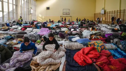 Getty Images Children rest in a temporary shelter for Ukrainian refugees in a school in Przemysl, near the Ukrainian-Polish border