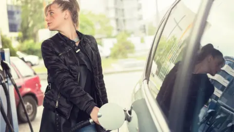 Getty Images Woman filling up car