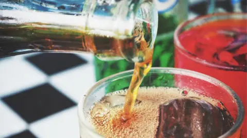 Getty Images Pouring drinks at a restaurant table