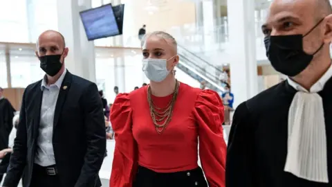 AFP Mila (C) arrives in court during the opening of the trial