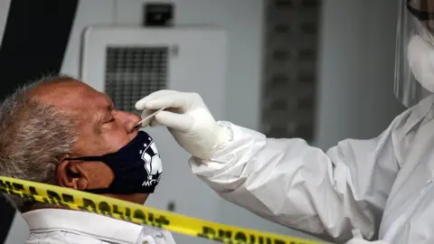 Reuters Mexican man undergoing nasal swab test