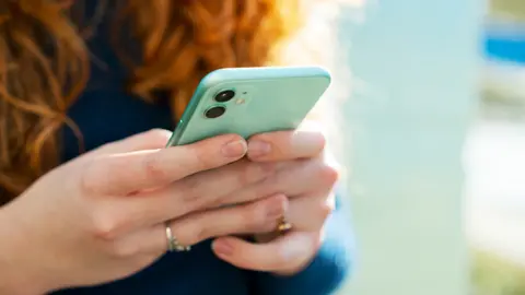 Getty Images Person looking at phone in hands