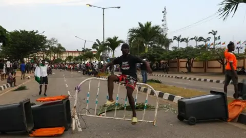 Reuters A protester sits on a barricade blocking a road in Lagos, Nigeria. Photo: 20 October 2020